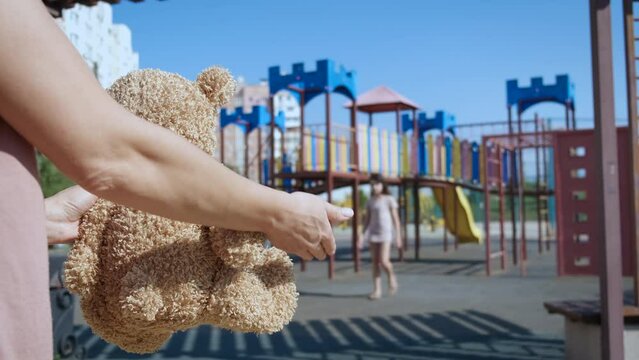 International kidnapping day. A view of somebody ask the child with teddy bear toy on playground. A concept of kidnapping day.