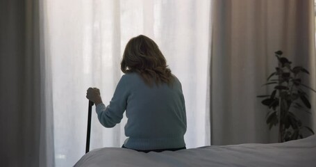 Thinking, sad and window with old woman and walking stick in bedroom for wellness, retirement and healthcare. Depression, mental health and nursing home with patient with a disability for support