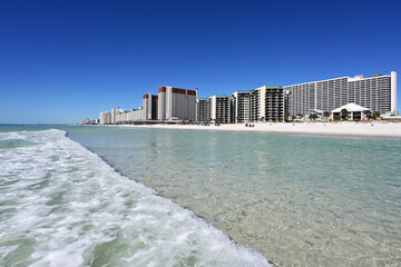 White sand beach, crystal clear water and beachfront residential buildings of Panama City Beach,...