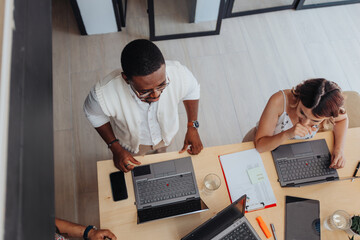 A confident business group analyzing statistics and reports, working together in a modern office room. They focus on teamwork, innovation, and digital marketing to maximize profit and minimize risks.