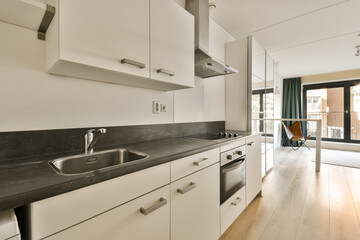 a kitchen with white cupboards and black counter tops on the counters in this apartment is very...