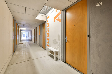 an empty hallway with orange and white paint on the walls, and a sign that says no one is there