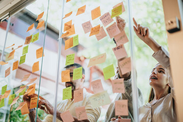 Multiracial business team brainstorming, planning, and collaborating in a modern office. Glass...