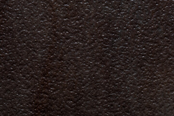 Dark textured background image resembling divoted or dimbled brown stone.