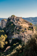 Walled fortress of Xativa, Spain, perched atop a rocky promontory in the golden light of dawn.