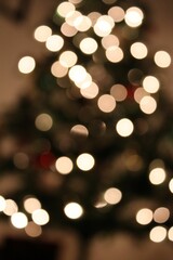 Blurred Christmas tree with bright yellow-white bokeh lights