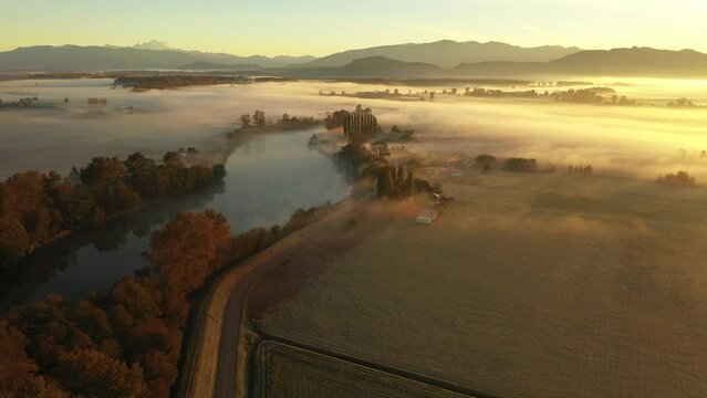 Dramatic Aerial Sunrise Over the Skagit Valley on a Foggy Morning.  Autumn in the Skagit Valley means ground fog adding to the atmospheric feeling in this agricultural area of western Washington state