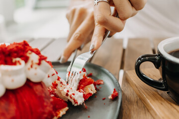 Cake being eat by woman in the cafe. Focus selective on the cake.