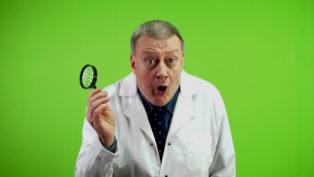 Senior Doctor Holding Magnifying Glass Looking Forward And Have Surprised Face.