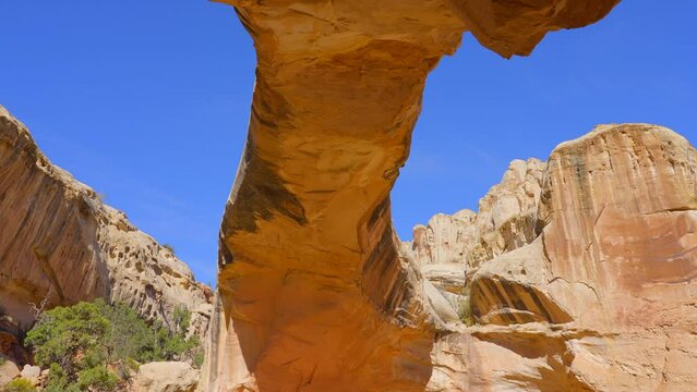 Establishing shot of mountain trail with red rocks background in Hickman Natural Bridge Trail, Capital Reef National Park, Utah, North America. Day time on October 2023. Still camera view. ProRes 422 