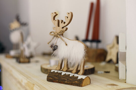 Christmas composition with beautiful decoration, christmas tree and wooden deer, horse, stars and other accessories in modern home.