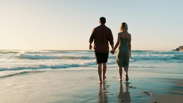 Beach, back and couple holding hands while walking at sunset with love, freedom or bond in nature, Travel, sunrise and people at ocean for summer, vacation or holiday, journey or adventure in Mexico