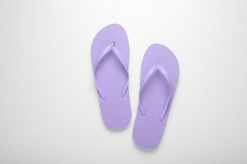 Stylish violet flip flops on white background, top view