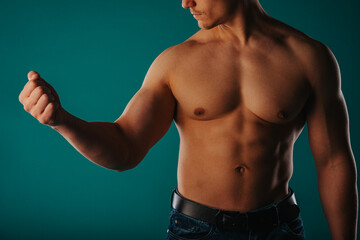 Strong man flexing his biceps in studio after work out