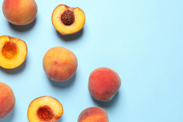 Cut and whole fresh ripe peaches on light blue background, flat lay. Space for text
