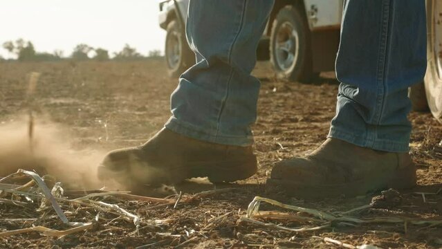 Farmer's boot kicking up dust in field during Australian Drought