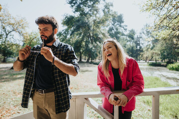 Best friends enjoying a carefree conversation on a park bridge in a sunny city park. Their positive...