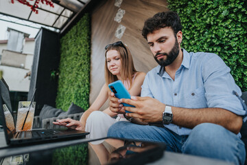 Young business couple discussing growth strategies at a coffee bar in the city center. Successful entrepreneurs planning for corporate expansion and increased profitability.