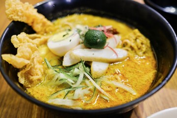 A bowl of Nyonya laksa with rice vermicelli, shredded chicken, fried bean curd, boiled egg, julienned cucumber, bean sprout, fish balls, calamansi lime, sambal paste at Limapulo, Chow Kit - Malaysia