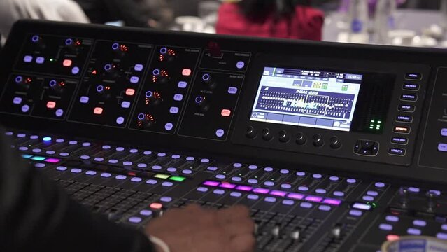 real sound maestro navigates the mixing board at a live event checking audio levels