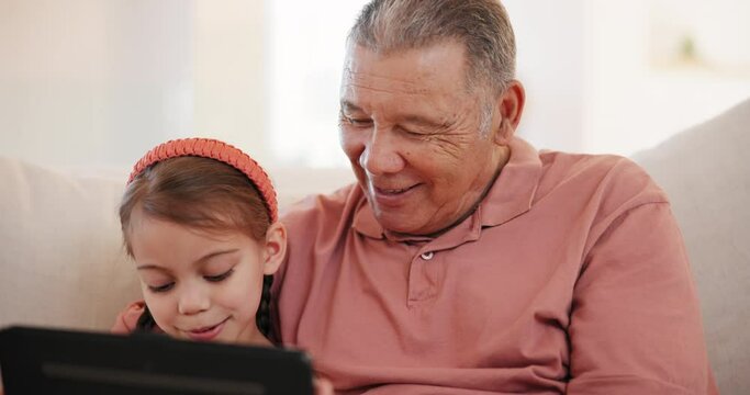 Smile, tablet and grandfather with child on a sofa in living room networking on internet in family home. Happy, love and senior man in retirement bond, relax and scroll on digital technology with kid