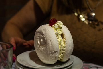 photograph of meringue with cream and dulce de leche and the dessert cherry