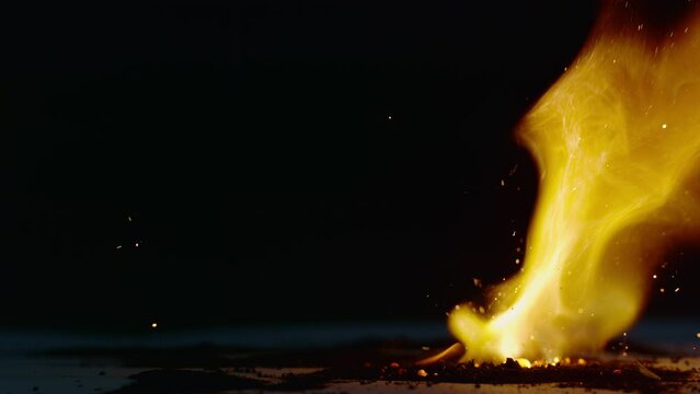 A large fire burns in a pit outside