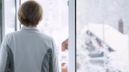 The woman opens the window, looks out and inhales the clean winter air - Powered by Adobe