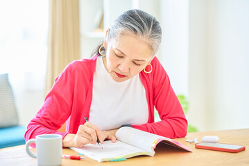 テキストで勉強しているシニア女性