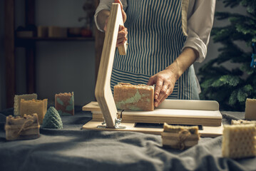 Cutting of homemade natural soap on a professional wood cutter. A means of eco-friendly hygiene and...