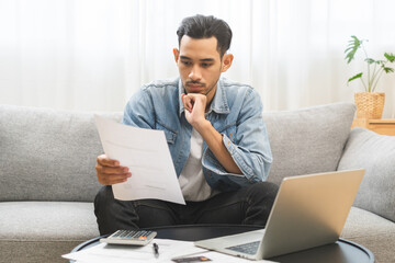 Bad financial concept, frustrated asian young man, male having debt, reading paper report from...