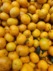 Close up pile of oranges sold at the market as a background.