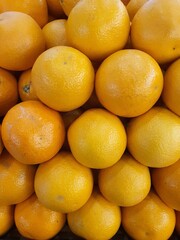 Close up pile of oranges sold at the market as a background.