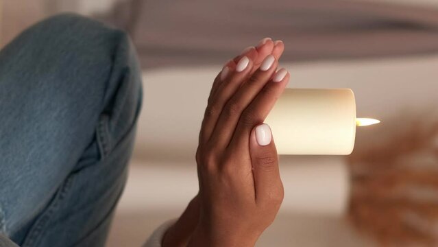 Vertical video. Saint's day. Candle praying. Religious tradition. Meditating woman holding burning remembrance flame wax light at home.