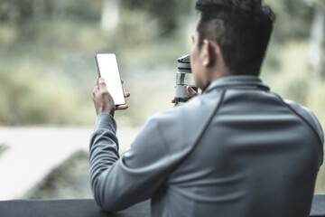 A man use smartphone use Fitness application, social media, listening to music.  Health and Lifestyle in big city life concept.