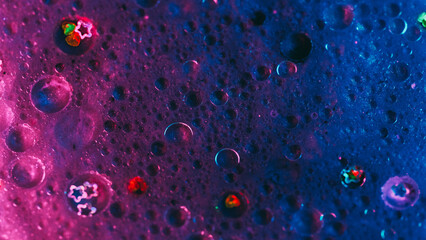 Abstract background. Paint mix bubbles. Shimmering liquid art. Neon purple blue glowing circles with shiny sequins hypnotic creative motion.