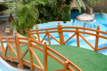 Water fountain in aquapark. Mushroom shape fountain in indoor adventure park full of green palm...