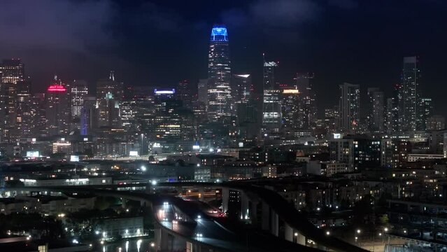 Scenic views of modern contemporary city with night illumination. Aerial views of traffic multi levered highway California USA. Cinematic panorama of night San Francisco downtown at night illumination