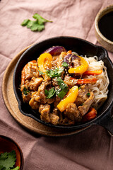 Asian pork with vegetables and glass noodles in a pan vertical photo