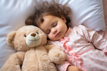 Obraz na płótnie Canvas Toddler girl with dark hair in shirt sleeps sweetly in company of best friend teddy bear seeing pleasant dreams. Little girl has sweet dreams in bed with favorite toy small teddy bear