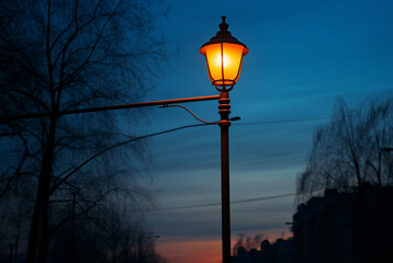 Street lamp sitting by the road under the sky of sunset - Powered by Adobe