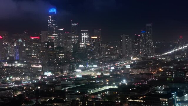 Aerial views of traffic multi levered highway California USA. Cinematic panorama of night San Francisco downtown at night illumination. Scenic views of modern contemporary city with night illumination