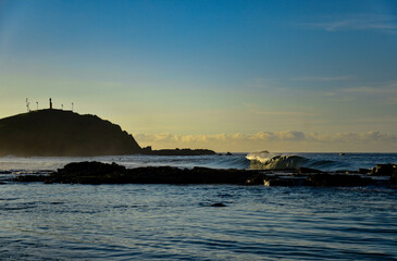 Sunrise at the beach with waves breaking lit by the sun