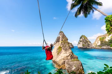 Fototapeten Bali Young woman tourist on Bali swing at Diamond beach at Nusa Penida island Bali, Indonesia  © Kittiphan