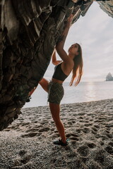 Sports Woman Climbing The Rock. Young woman With slim fit body climbing in volcanic basalt cave...