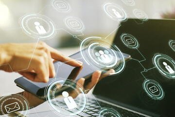Double exposure of social network icons concept and hand working with a digital tablet on background. Networking concept