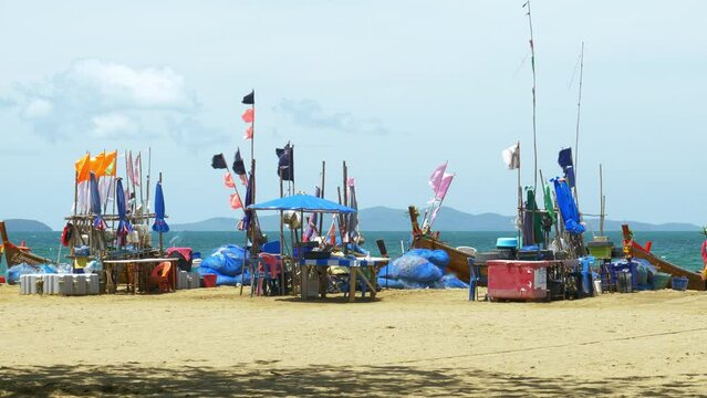 A fishing area in Pattaya where fishermen gather with their fishing boats, nets, and other equipment like ice boxes, tables, and chairs for sorting their catch for the day, in Chonburi, Thailand.