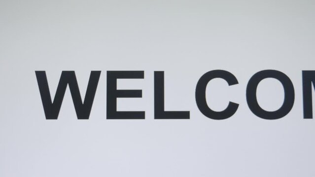 Digitally typing the word welcome in an upper case font, with the use of a keyboard of a computer.