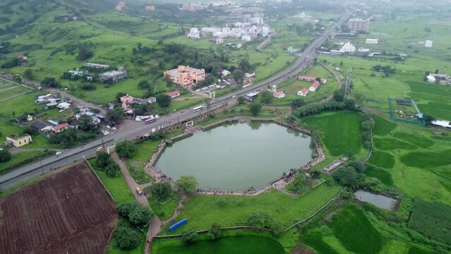 Scenic aerial view of a busy highway through the lush green agricultural fields in the rural part of Maharashtra, India