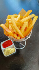 French fries in basket with ketchup and sauce